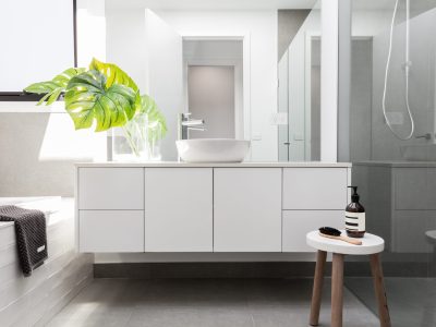 Luxury white family bathroom styled with greenery and a wooden stool